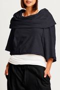 Person wearing a jackie o french terry top over a white shirt and black pants on a light gray background