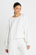 Woman wearing a white outfit against a light gray background