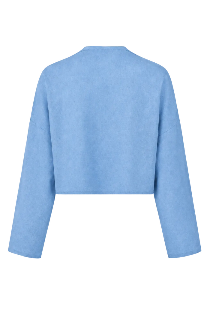 A 100% linen light blue cropped long-sleeve sweater shown from the back on a plain white background.