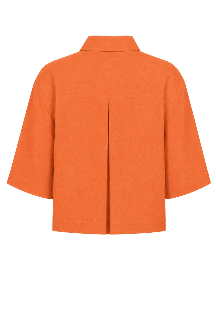 An orange short-sleeve 100% linen collared shirt shown from the back, featuring a central vertical pleat detail, on a plain white background.