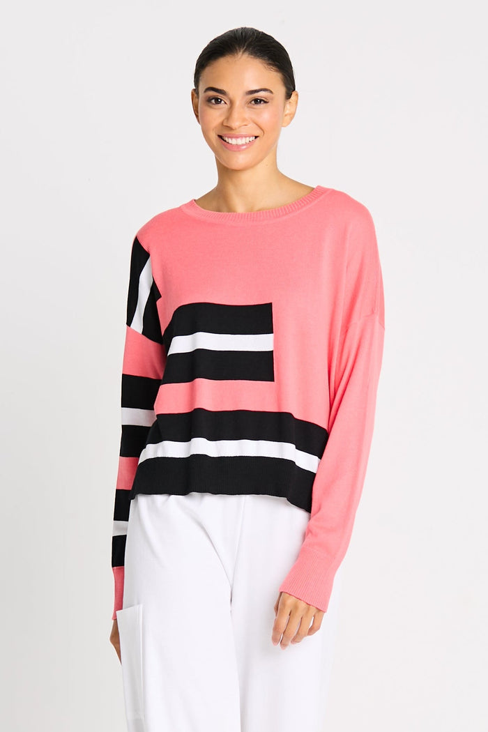 Woman wearing a pink pima cotton shirt with black and white stripes on a plain background