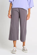 Person wearing gray pima cotton wide-leg flooded pants and a light purple top on a white background