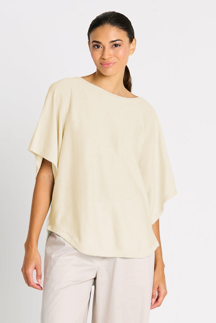 Woman wearing a light-colored pima cotton top and pants on a plain background