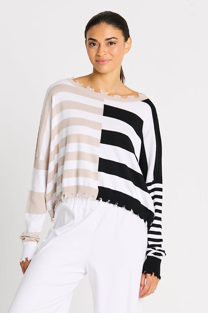 Woman wearing a black and white striped sweater on a beach