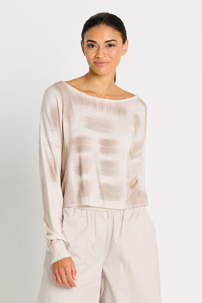Woman wearing a beige tie-dye long-sleeve top and pants on a white background