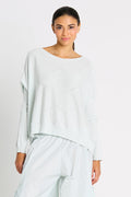 Woman wearing a light mint sweater and pants on a white background