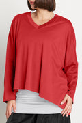 Red long-sleeve top worn by a woman on a plain background