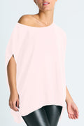 Person wearing a light pink off-shoulder top against a light blue background